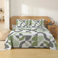 Bed with geometric patterned comforter in a bedroom setting
