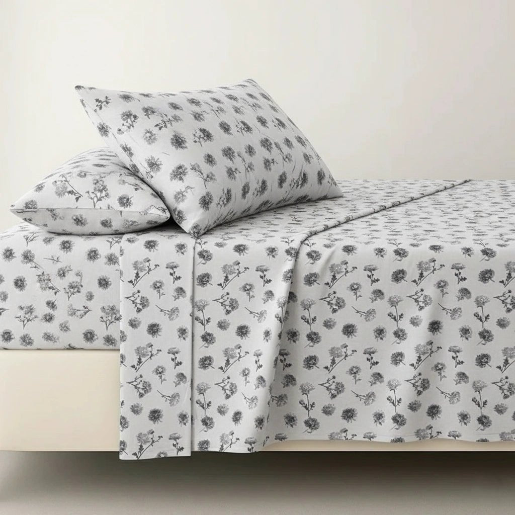 Floral patterned bed sheets and pillowcases on a bed with a plain background