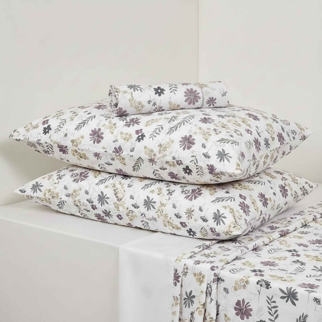 Floral patterned bed sheets and pillows on a white background