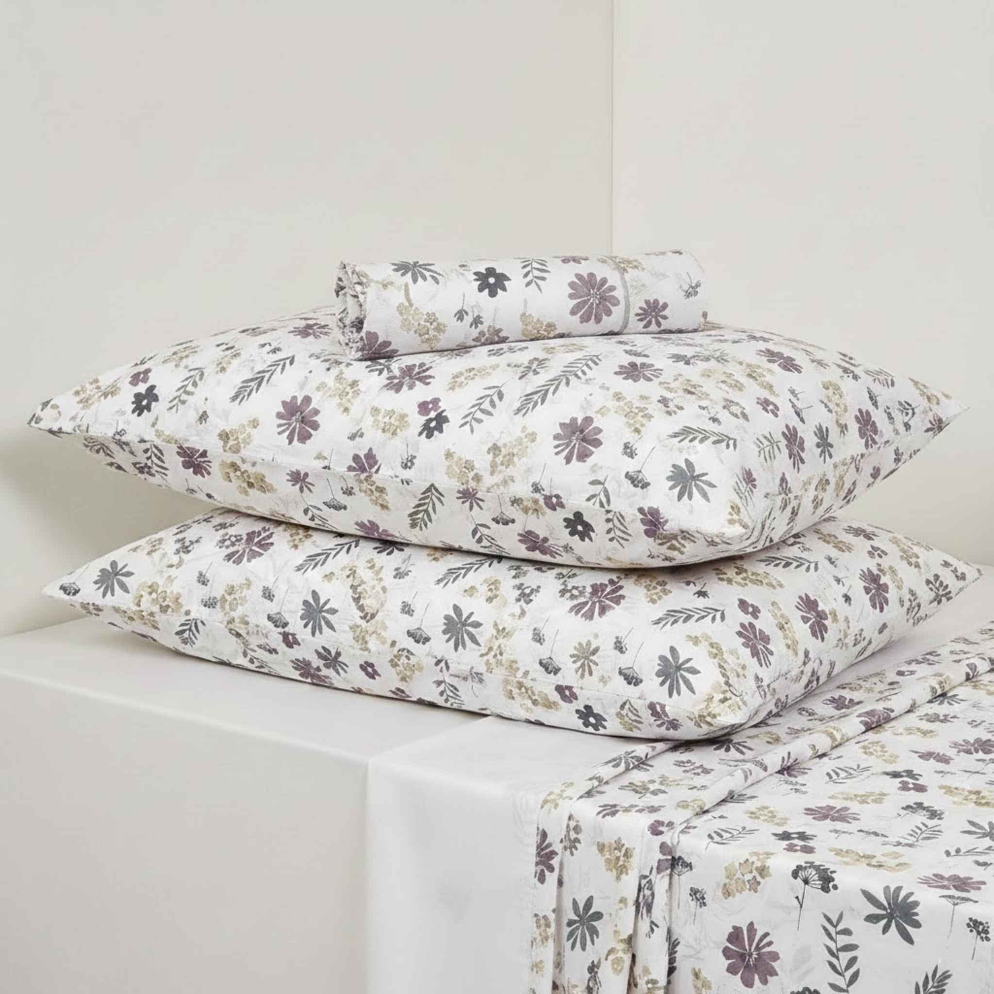 Floral patterned bed sheets and pillows on a white background
