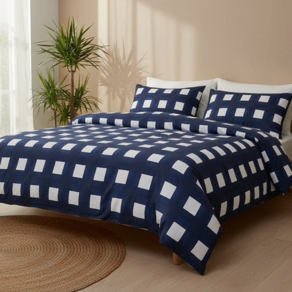 Blue and white checkered bedding set on a bed with plants and sunlight in the background